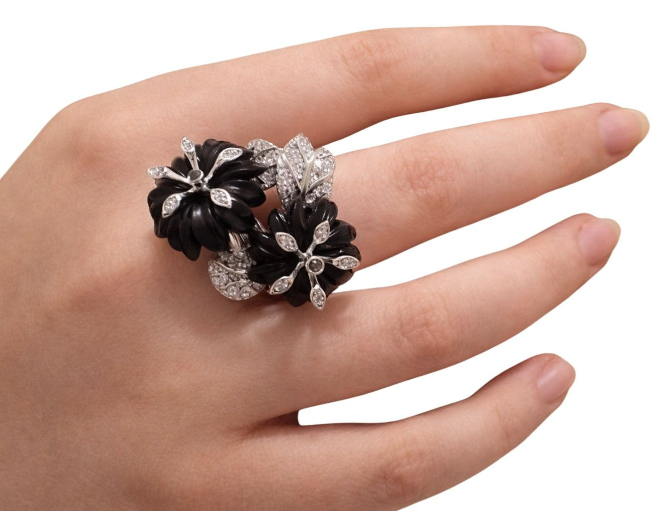 Angled on-hand view of the Black Petunia statement ring with carved black flowers and pavé diamond leaves