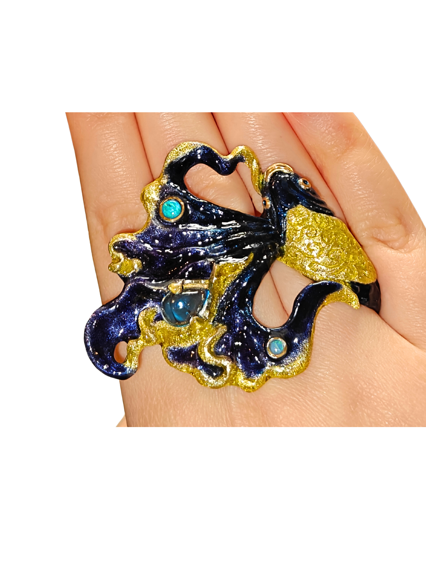 Close-up of the Ocean Duet ring worn on a hand from the Stone Garden Collection by Konforti Jewelry, handcrafted in 960 silver and adorned with 3 ct blue topaz and 0.01 ct opal gemstones, featuring hand-painted Limoges enamel that evokes ocean waves and movement.