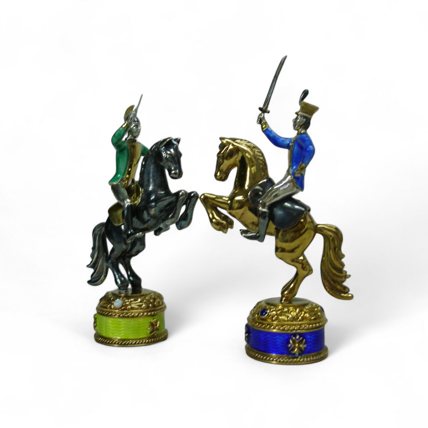 Close-up of two silver knight sculptures from the Napoleon vs Alexander I chess set, showing fine sculptural details, enamel work, and gemstone bases.