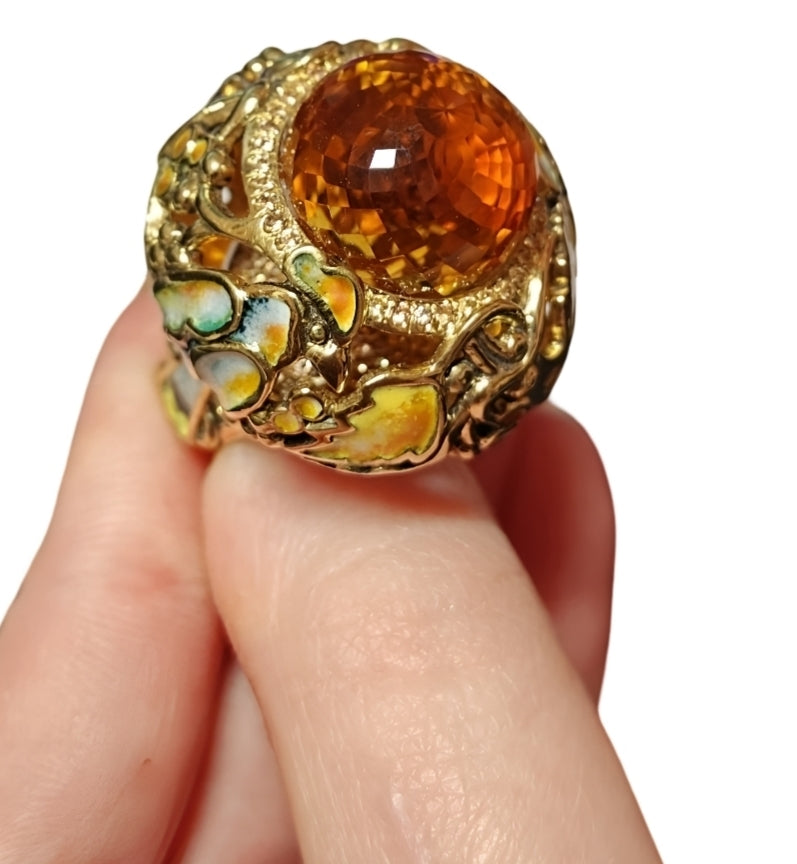 Close-up of citrine madeira gemstone set in yellow gold with intricate enamel paintings, fine jewelry design by Konforti Jewelry