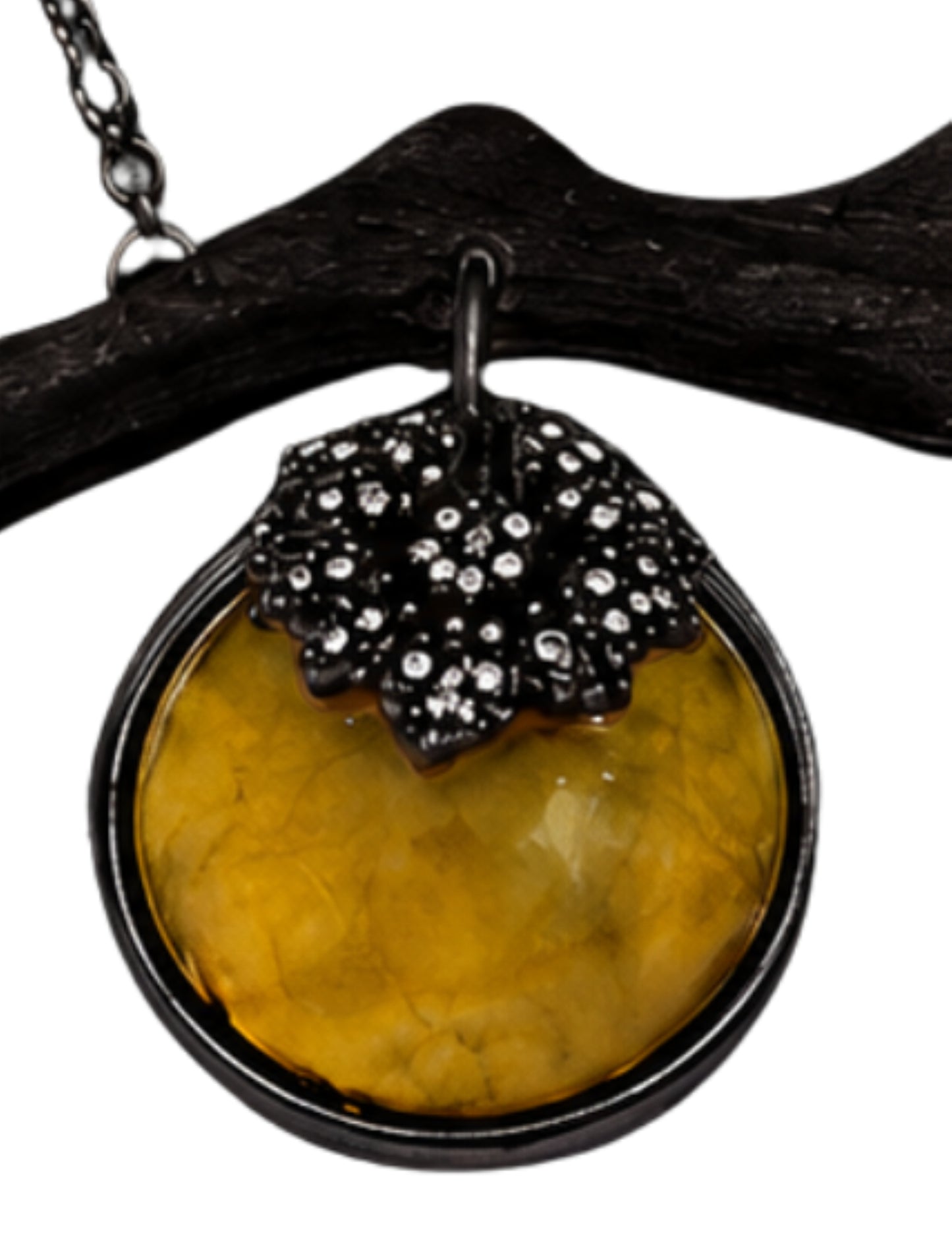 Close-up of carved golden lepidolite persimmon with diamond-set black rhodium calyx on an artistic luxury pendant.