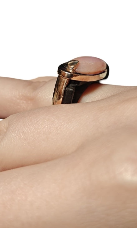 Close-up of pink opal gemstone set in 14K pink gold, ebony wood carving detail, Konforti Jewelry fine craftsmanship