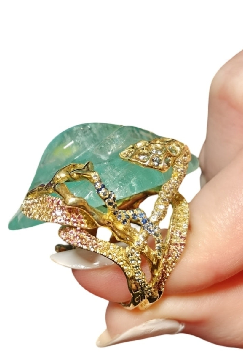 Summer Pond ring showcasing 11 colors of sapphires set in 18K yellow gold, with detailed enamel and aquamarine centerpiece