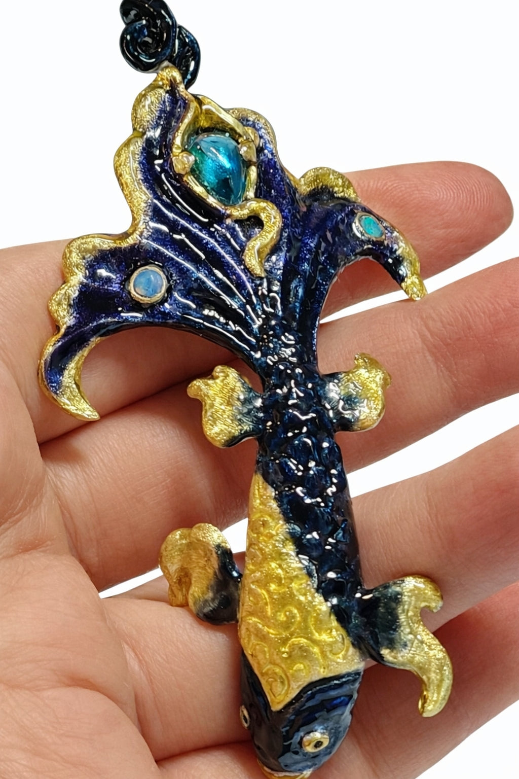 Statement betta fish pendant worn on hand showing scale and intricate Limoges enamel detailing with blue topaz and opal gemstones in collectible artisan jewelry.