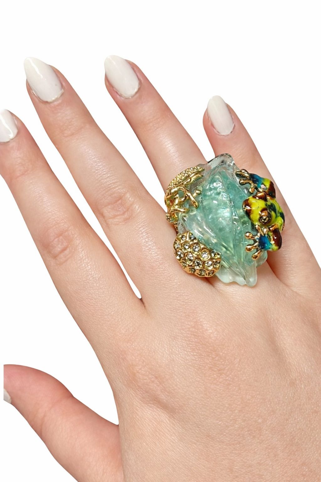 Top view of an enamel frog figure resting on a carved aquamarine gemstone