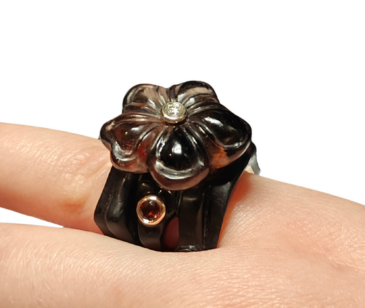Front close-up of the Midnight Blossom ring from the Stone Garden Collection by Konforti Jewelry, handcrafted in 14K pink gold and black ebony wood, featuring a hand-carved smoky quartz flower with tourmalines and a diamond center.