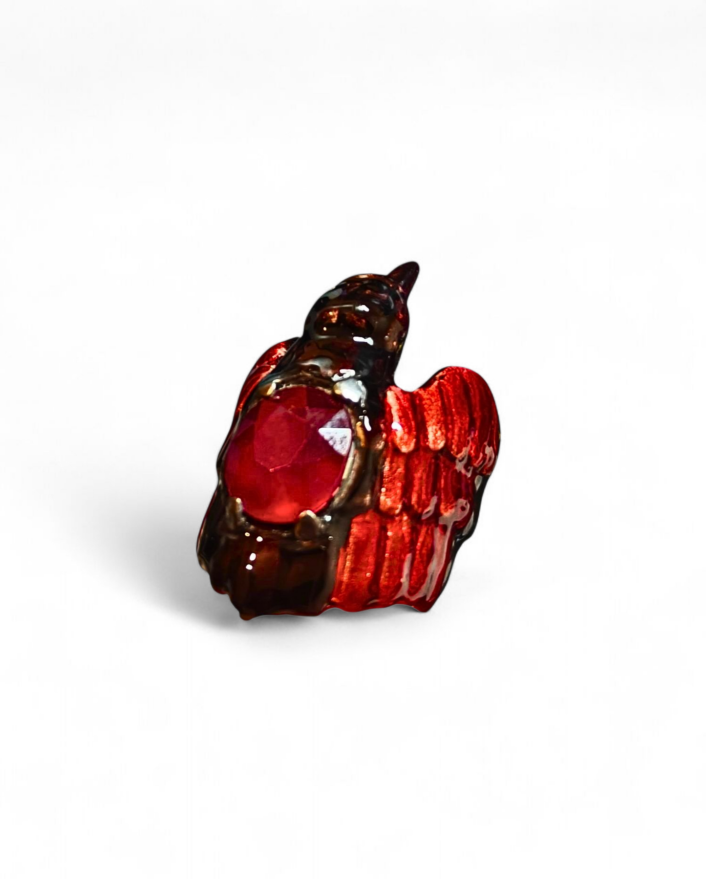 Side view of the Royal Raven ring from the Stone Garden Collection by Konforti Jewelry, handcrafted in 960 silver and crowned with an 8.45 ct treated ruby. The design features Limoges-style hot enamel paintings and 24K gold plating that give the piece depth, contrast, and regal character.