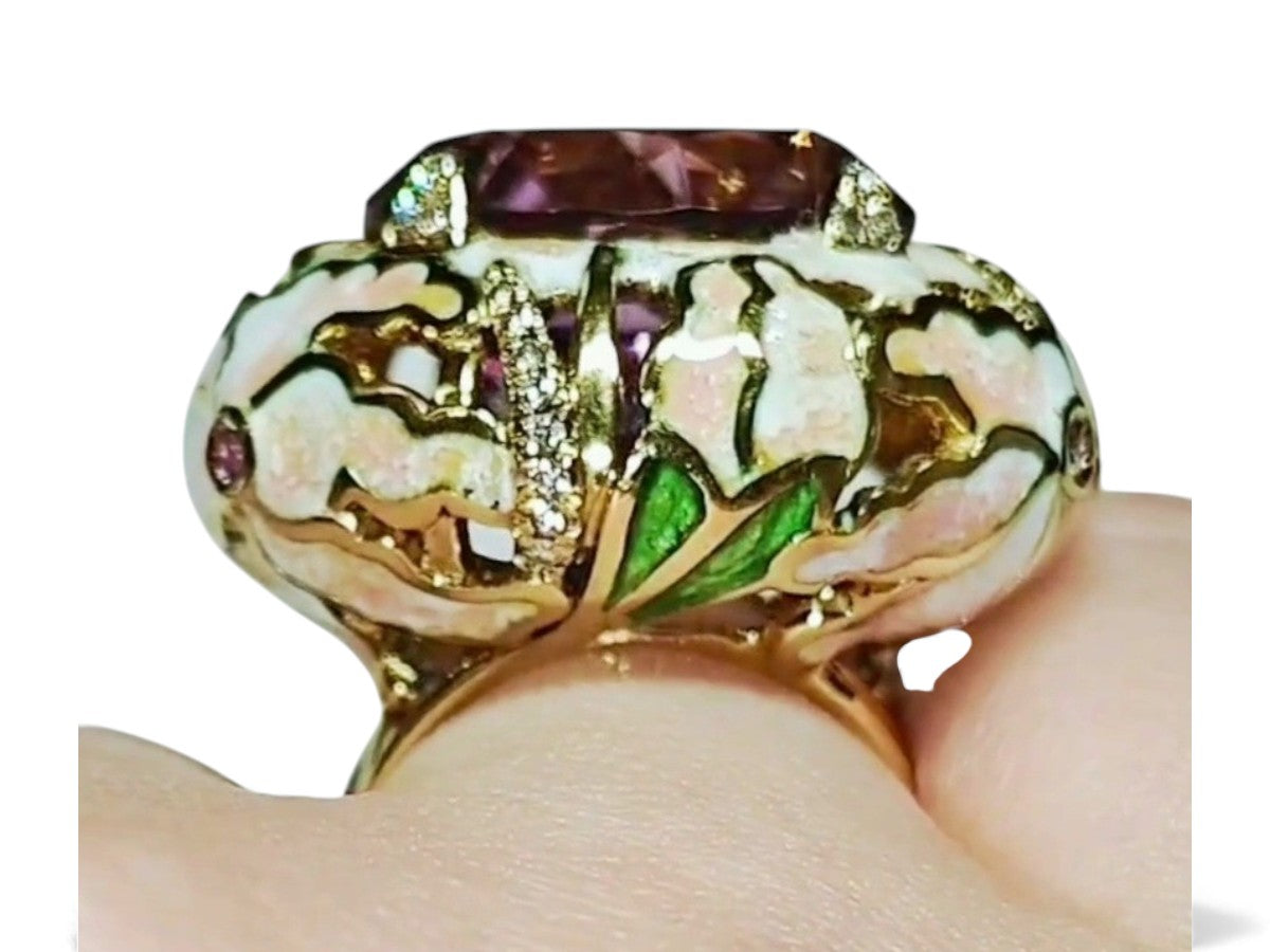 Different angle of the ametrine lily ring worn on the hand, showing the vivid color zoning of the 32ct ametrine, detailed enamel lilies, pink sapphires, and diamond highlights.