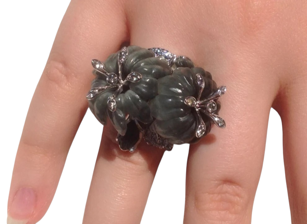 Close view of the Asian Lilly ring on the hand, focusing on the sculpted cat’s eye flower carvings, shimmering grey sapphires, and polished white gold craftsmanship.