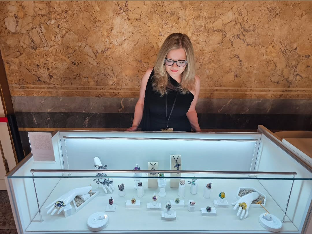 Inga Konforti of Konforti Jewelry presenting an 18K gold ring with hand-carved gemstone flowers to visitors at Milano Jewelry Week 2025.