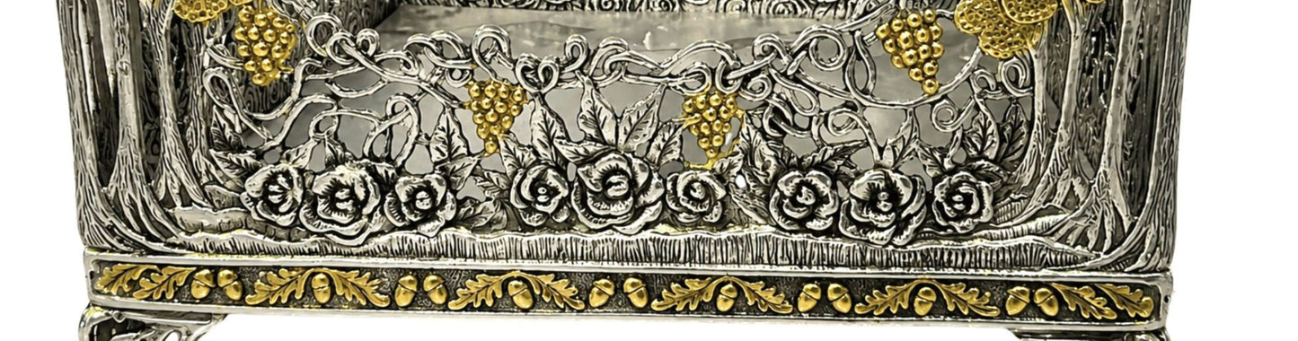 Detailed view of sculpted silver roses, grapevine openwork, and 18K gold gilded grape clusters on Royal Garden napkin holder.