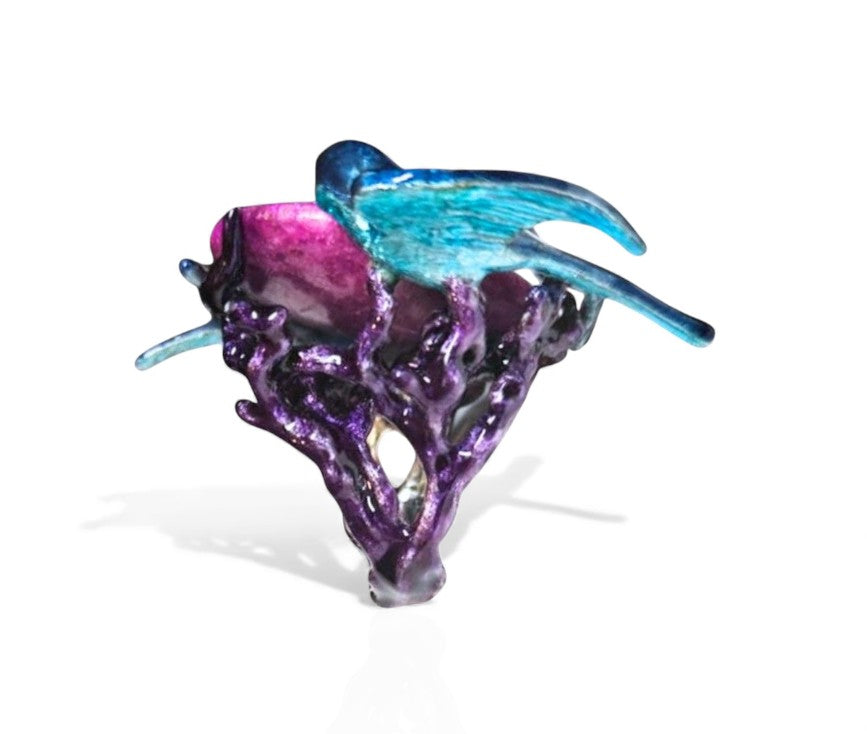 Angled image of the Celestial Flight ring showcasing the luminous carved purple moonstone, vibrant enamel painting, and the 24K gold-plated details enhancing the 960 silver setting.