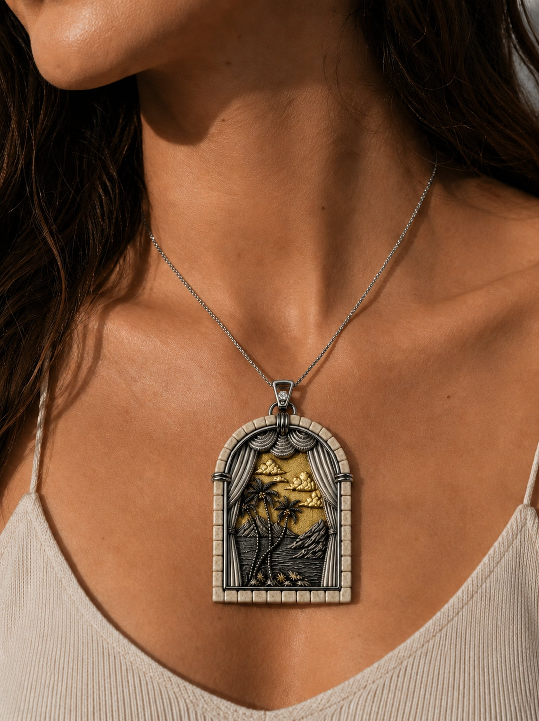 Woman wearing the Days of Creation Third Day pendant in sterling silver, 24K gold gilding, Jerusalem stone, and diamond, showcasing the pendant's couture scale and sculptural biblical landscape design.
