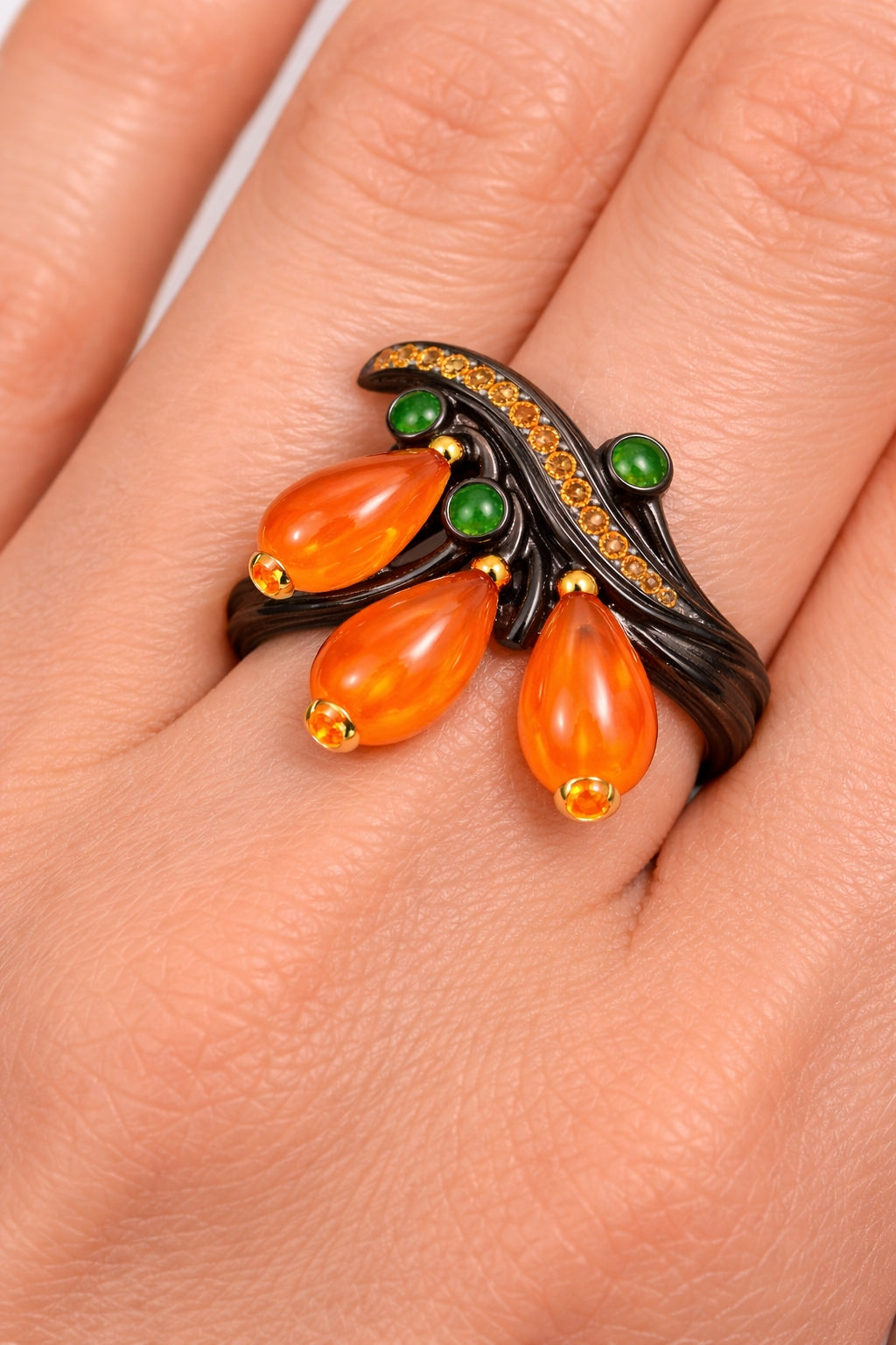 Ebony wood and nephrite statement ring worn on hand, featuring tsavorites and sapphires set in 18K gold