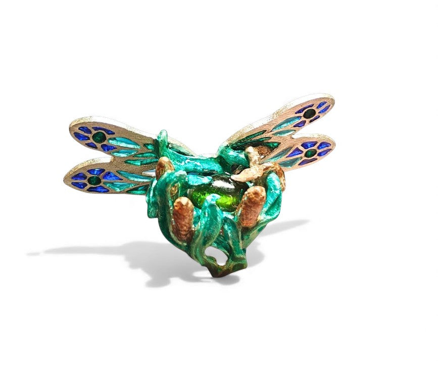 Top view of the Enchanted Dragonfly ring highlighting the dragonfly’s plique-à-jour wings, the vivid 7.5ct green tourmaline, and the intricate enamel work on the 960 silver setting.