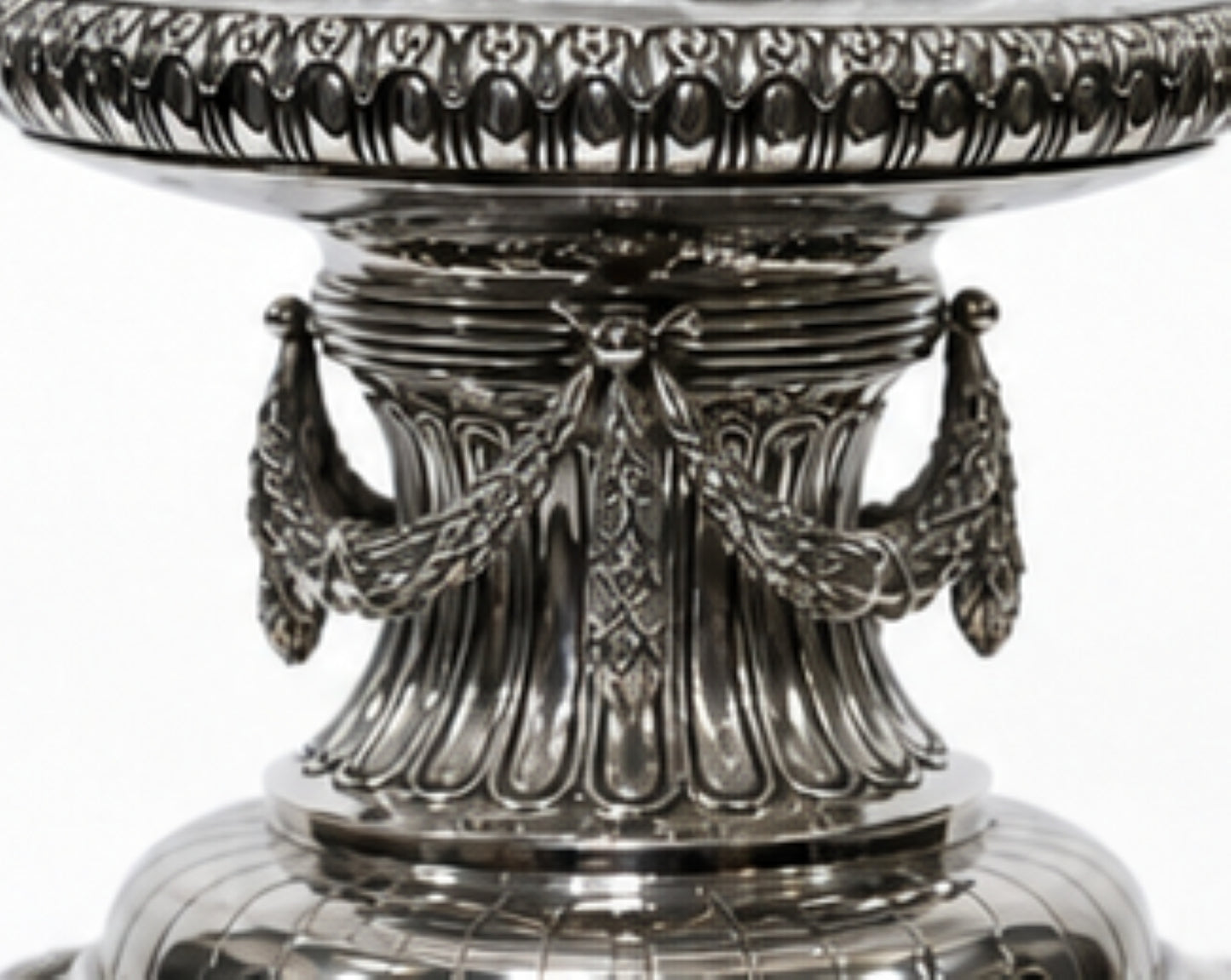 Close-up of the sculptural sterling silver column featuring engraved garlands and classical decorative elements beneath a crystal centerpiece bowl.