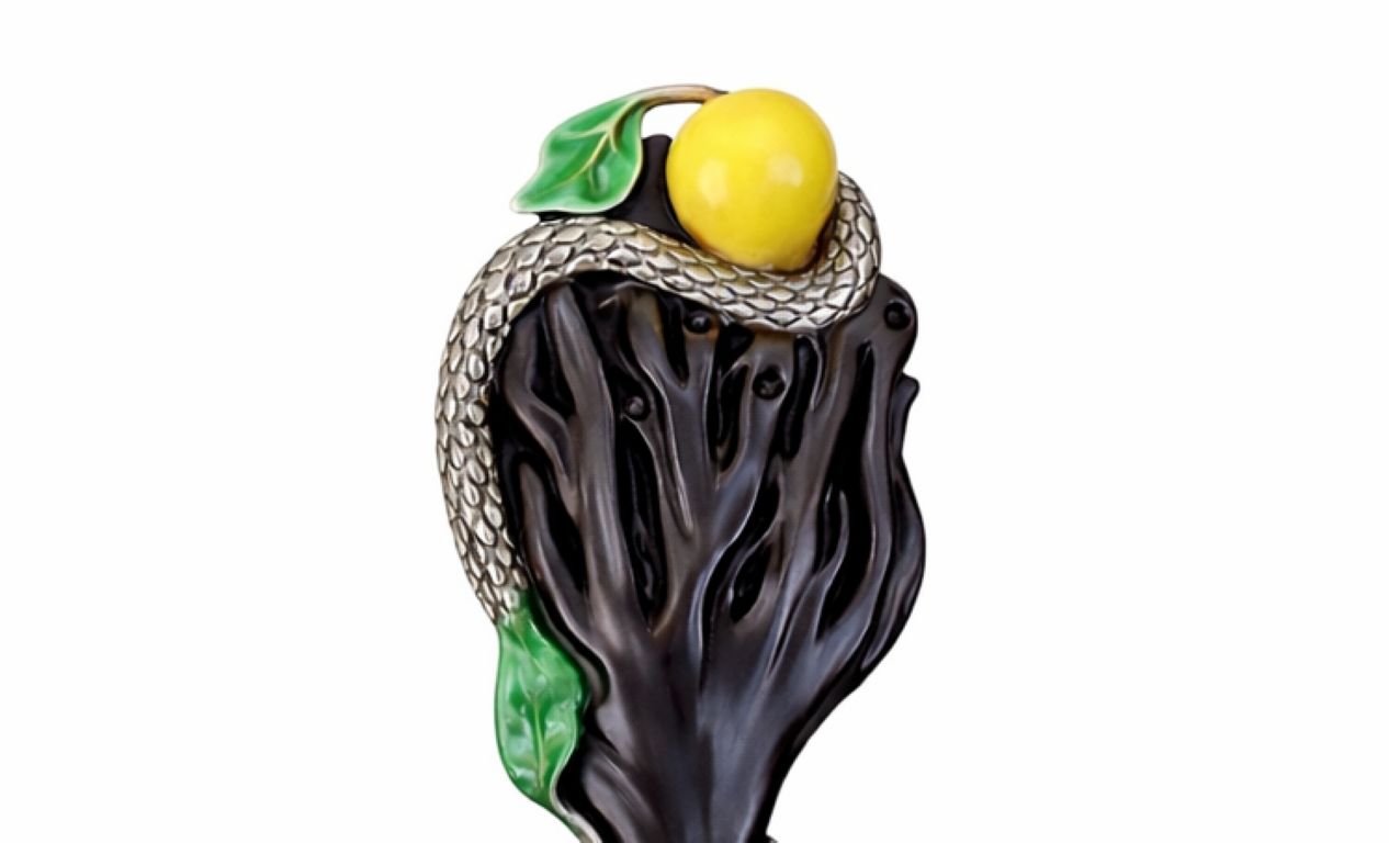 Luxury sculptural detail of serpent wrapped around ebony wood with jade apple and enamel leaves, Garden of Eden theme