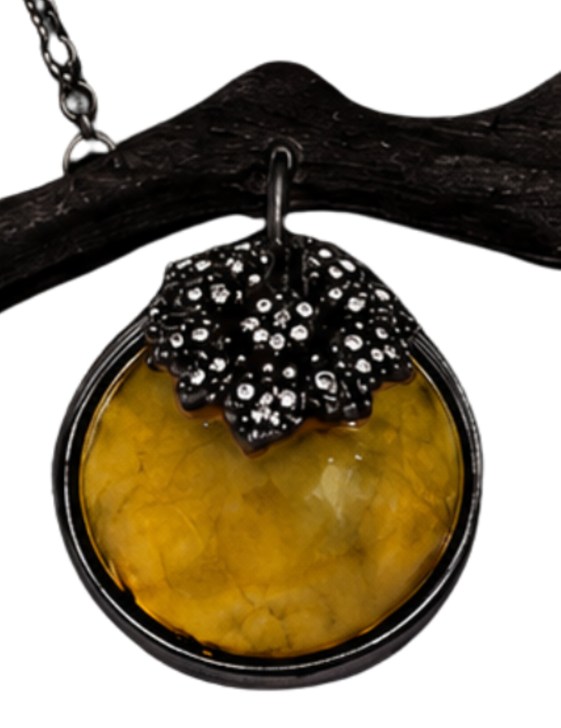 Close-up of carved golden lepidolite persimmon with diamond-set black rhodium calyx on an artistic luxury pendant.