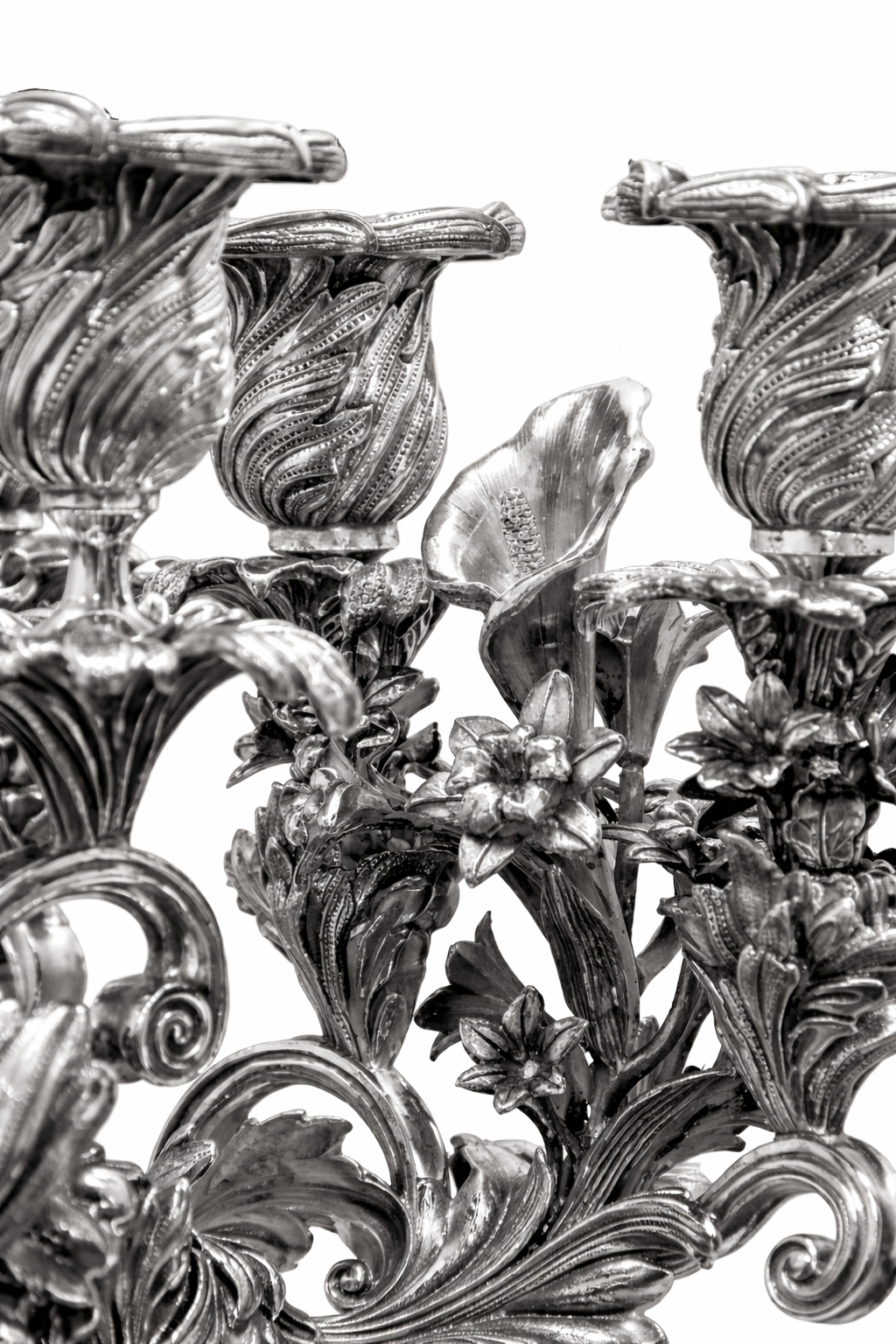 Detailed view of sterling silver menorah candle holders with engraved floral textures and refined artisan metalwork