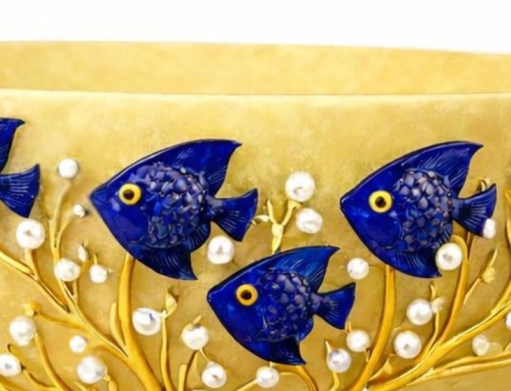 Close-up of lapis lazuli fish and freshwater pearls on gold vermeil coral branches decorating yellow jade bowl