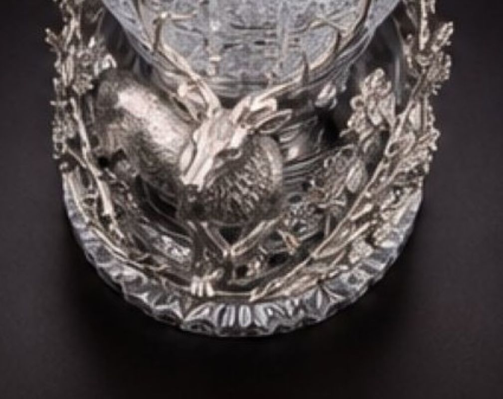 Close-up of the sterling silver woodland base with sculpted stag, branches, leaves and detailed forest vegetation.