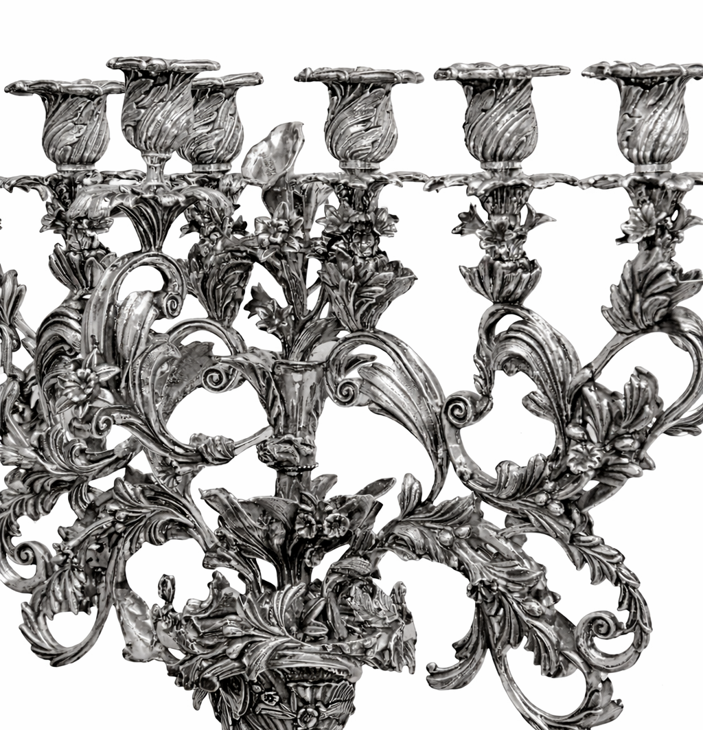 Central structure of luxury silver menorah featuring layered botanical motifs, high relief sculpting, and hand finished textures