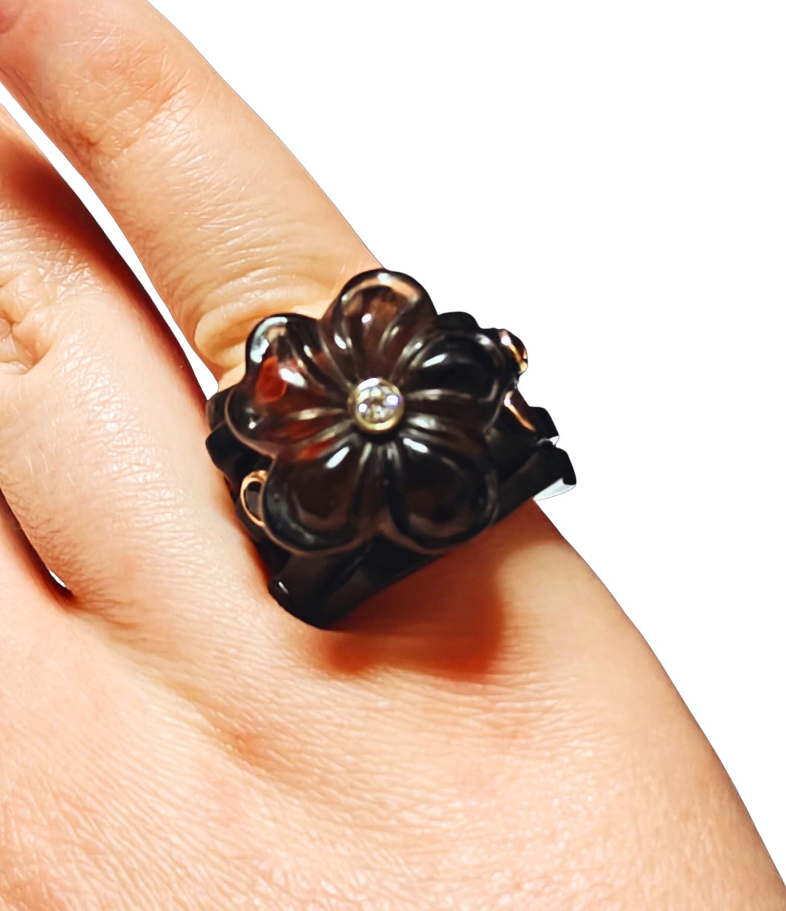 Top view of the Midnight Blossom ring on hand, featuring a hand-carved 28 ct smoky quartz flower set on ebony wood with a 14K pink gold inner band, accented by 0.85 ct tourmalines and a 0.17 ct diamond from Konforti Jewelry’s Stone Garden Collection.