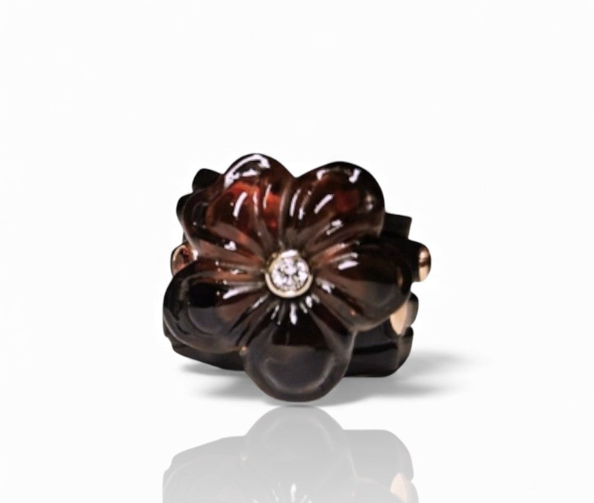 Top view of the Midnight Blossom ring highlighting the 28ct hand-carved smoky quartz flower, the diamond set at its center, and the surrounding 0.85ct tourmalines arranged within the ebony and pink gold design.