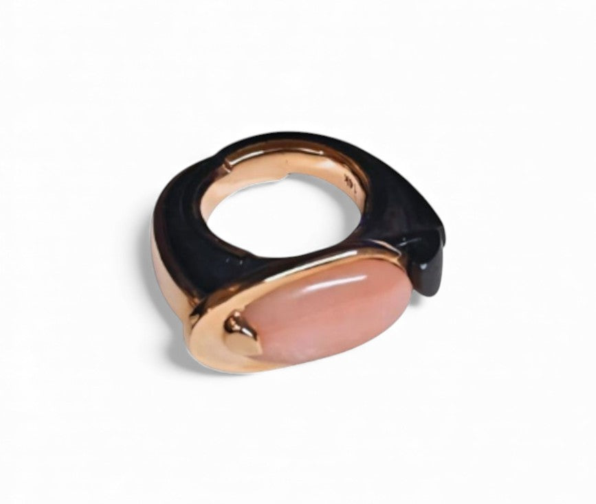 Top view of the Modern Muse ring showing the polished 6ct pink opal centerpiece, the 14K pink gold construction, and the hand-carved ebony wood foundation.