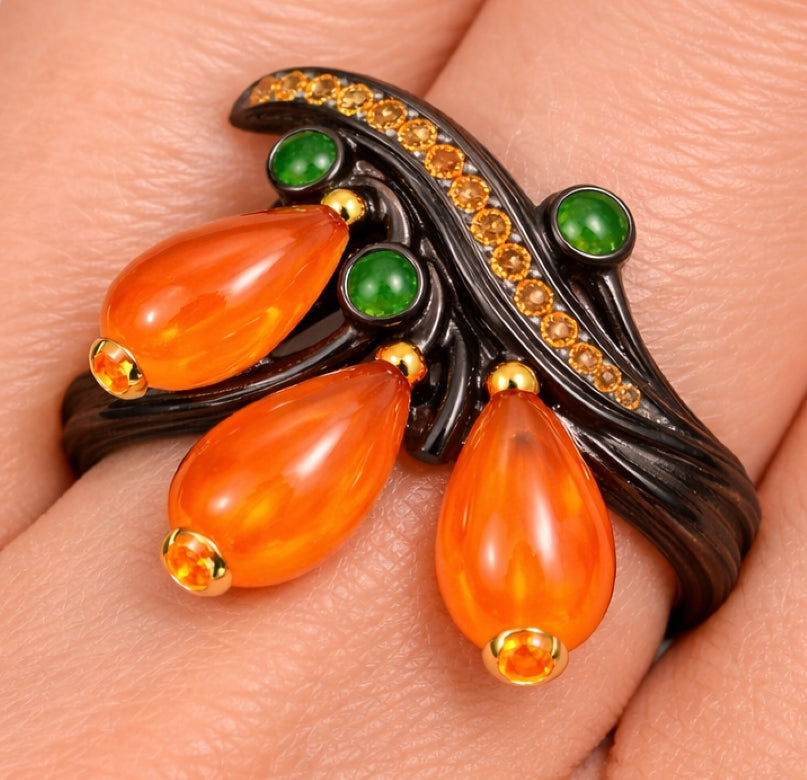 Close up detail of nephrite, tsavorite and sapphire setting in sculptural ebony wood and 18K gold ring