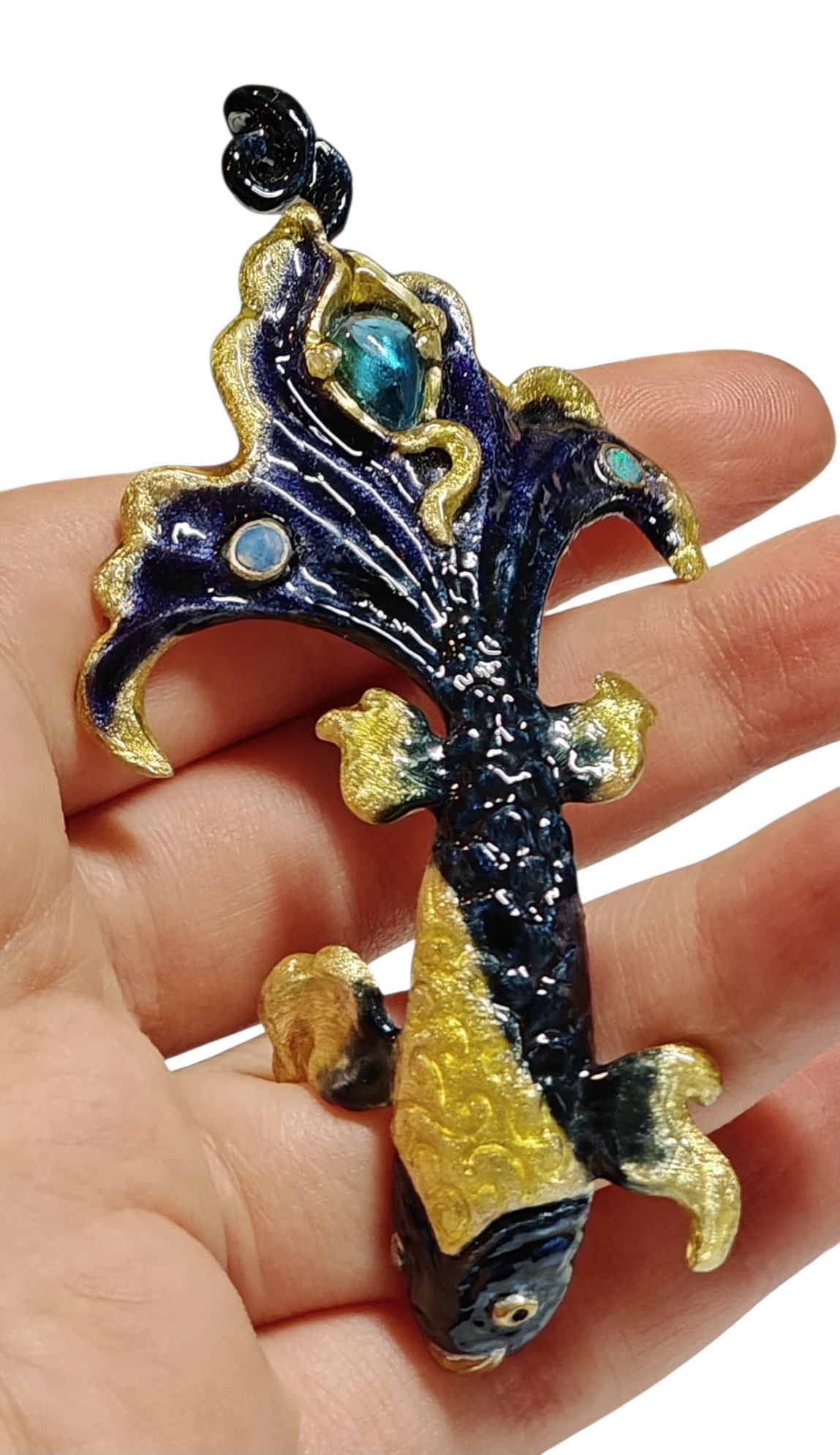 Ocean Duet pendant shown on hand, highlighting the blue topaz, opal accents, 960 silver craftsmanship, and the detailed Limoges enamel wave artwork from Konforti Jewelry’s Stone Garden Collection.