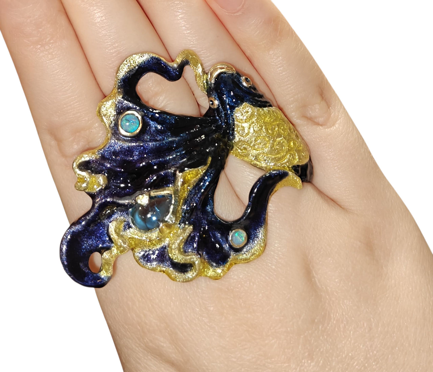 Ocean Duet 960 silver ring shown on a hand, highlighting the 3 ct blue topaz, opal accent, and the Limoges hot-enamel wave artwork from Konforti Jewelry’s Stone Garden Collection.