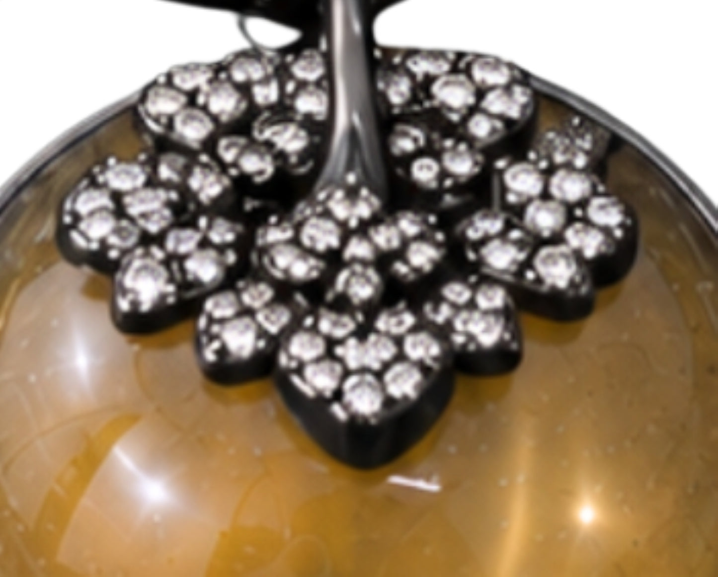 Macro view of pavé-set diamonds adorning the persimmon calyx and branch of the Golden Persimmon pendant in black rhodium-coated 18K gold.