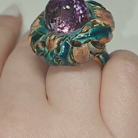 On-hand video of the Purple Thistle ring, showcasing the 18K yellow gold design with a 27.8 ct pear-shaped briolette amethyst hand-painted in layered Limoges-style enamel and accented with 1 ct white sapphires for added brilliance by Konforti Jewelry.