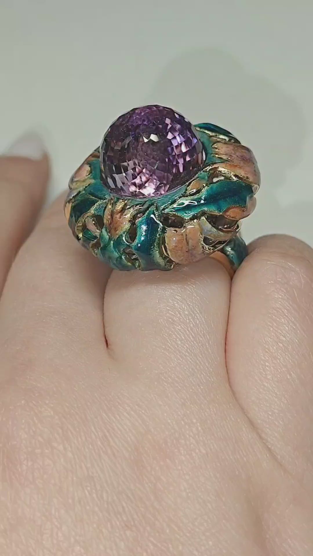On-hand video of the Purple Thistle ring, showcasing the 18K yellow gold design with a 27.8 ct pear-shaped briolette amethyst hand-painted in layered Limoges-style enamel and accented with 1 ct white sapphires for added brilliance by Konforti Jewelry.
