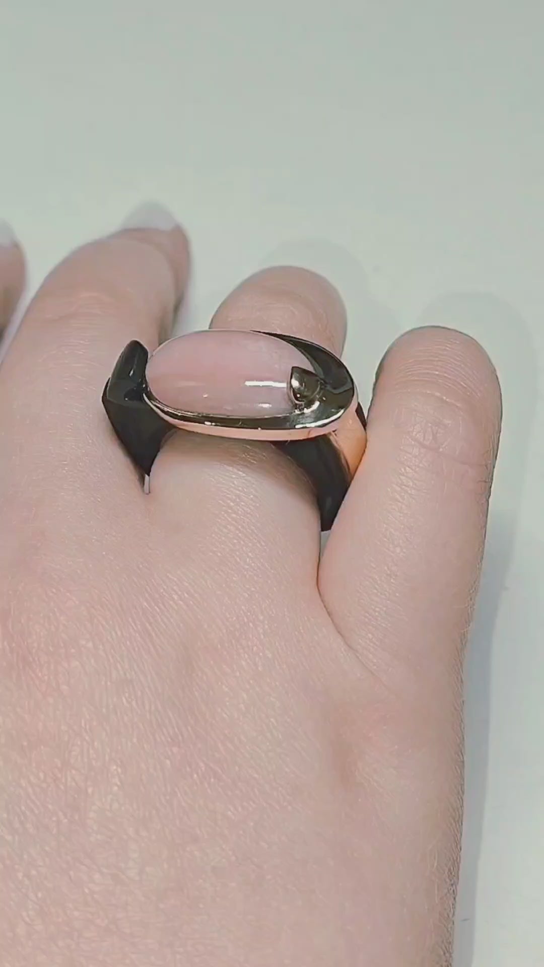 Modern Muse ring by Konforti Jewelry featuring a natural pink opal cabochon set in solid 14K pink gold with a hand carved black ebony wood sculptural band, shown in motion and worn on hand to highlight craftsmanship, materials, and contemporary design from the Stone Garden Collection