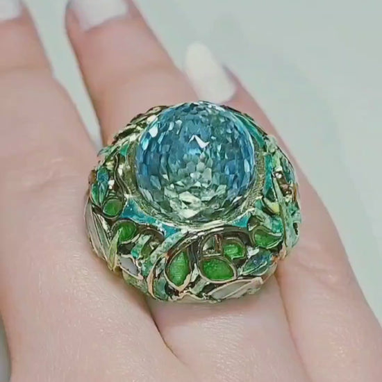 On-hand video of the Shimmering Pond ring, highlighting the 33.3 ct pear-shaped briolette Swiss topaz set in handcrafted 18K yellow gold with vivid Champlevé enamel detailing from Konforti Jewelry’s Stone Garden Collection.