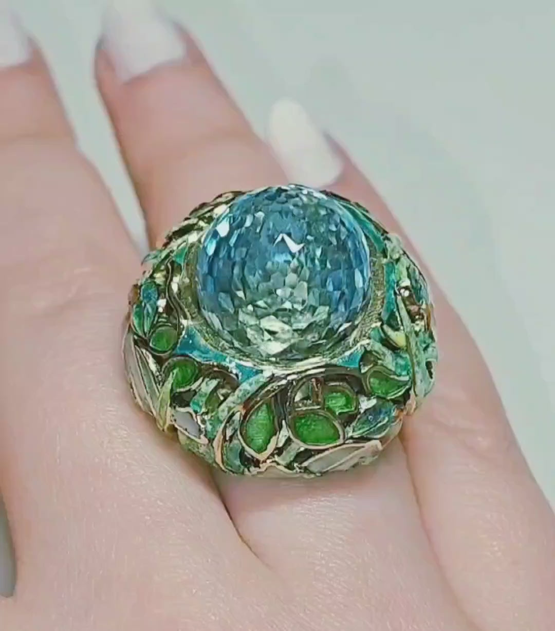 On-hand video of the Shimmering Pond ring, highlighting the 33.3 ct pear-shaped briolette Swiss topaz set in handcrafted 18K yellow gold with vivid Champlevé enamel detailing from Konforti Jewelry’s Stone Garden Collection.