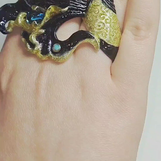 Video showcasing the Ocean Duet ring by Konforti Jewelry, handcrafted in 960 silver with a 3 ct blue topaz, 0.01 ct opal, and Limoges hot-enamel wave artwork inspired by the sea.