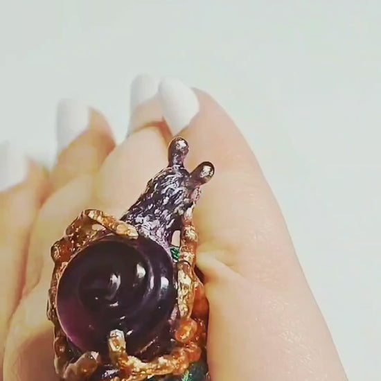 Video of the Amethyst Wanderer ring on hand, showcasing the handcrafted 960 silver snail-shell design, 29ct carved lab-grown amethyst, and vivid Limoges-style hand-painted enamel from Konforti Jewelry’s Stone Garden Collection.