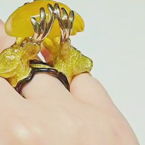 Video of the Guardians of the Sun ring by Konforti Jewelry on hand, showcasing the 960 silver stag designs, the hand-carved 90 ct yellow lepidolite gemstone glowing like sunlight, and the detailed hot enamel artwork from the Stone Garden Collection.