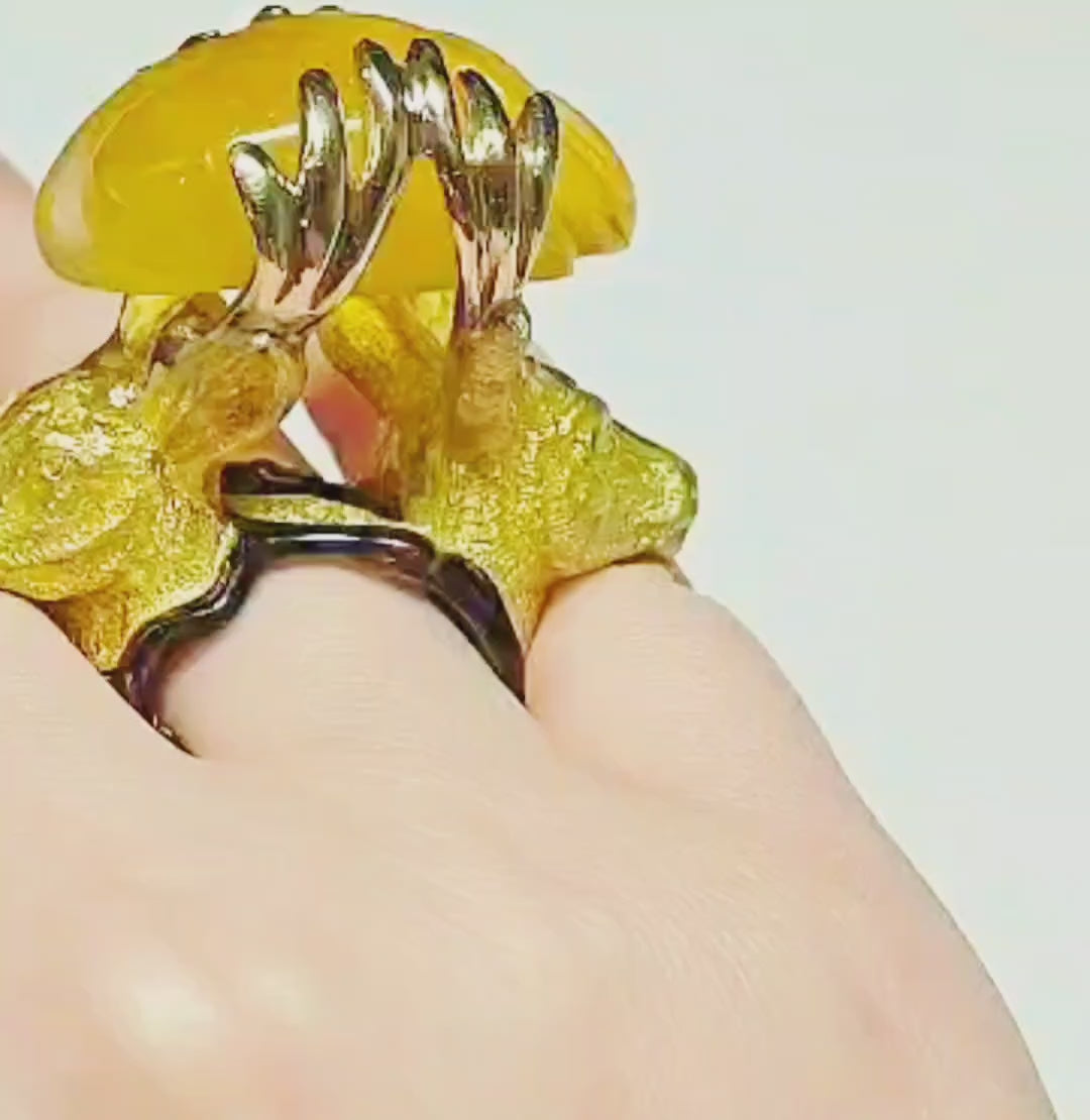 Video of the Guardians of the Sun ring by Konforti Jewelry on hand, showcasing the 960 silver stag designs, the hand-carved 90 ct yellow lepidolite gemstone glowing like sunlight, and the detailed hot enamel artwork from the Stone Garden Collection.