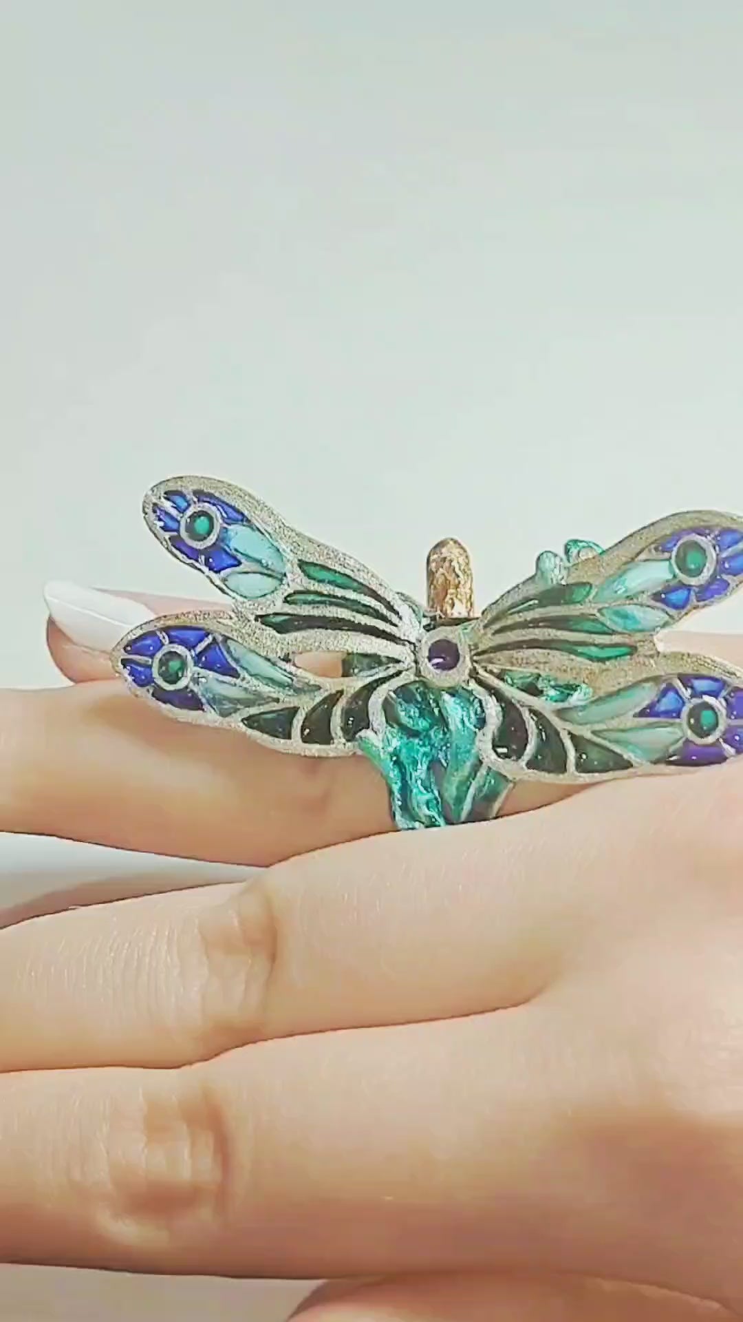 Video of the Enchanted Dragonfly ring by Konforti Jewelry worn on a hand, featuring a 7.5 ct green tourmaline set in handcrafted 960 silver with Limoges enamel and plique-à-jour dragonfly wings.