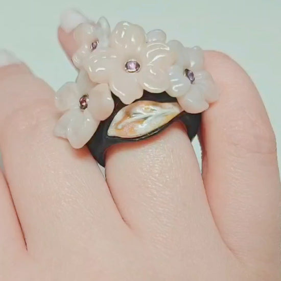 Pink Sakura ring by Konforti Jewelry featuring hand carved pink opal flowers with pink sapphire centers in gold settings on ebony wood band from the Stone Garden Collection shown in detailed rotating video