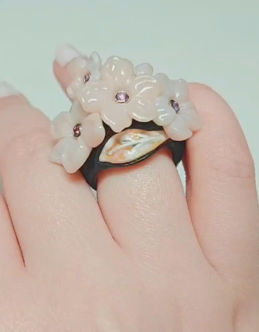 Pink Sakura ring by Konforti Jewelry featuring hand carved pink opal flowers with pink sapphire centers in gold settings on ebony wood band from the Stone Garden Collection shown in detailed rotating video