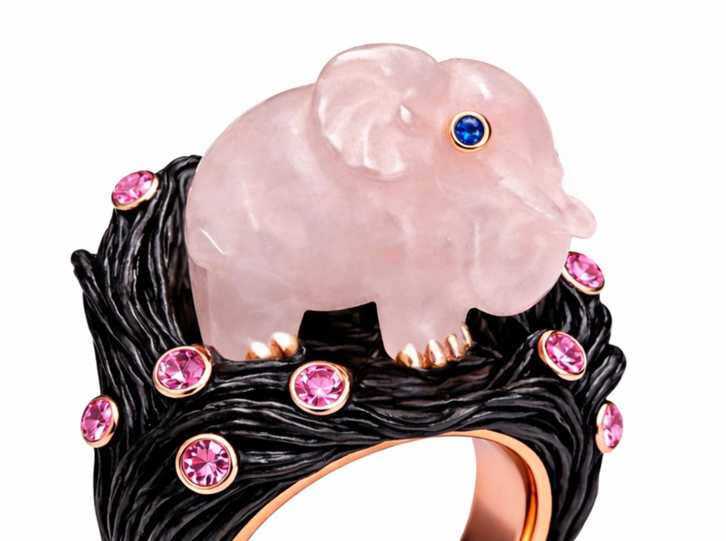 Side view of carved rose quartz elephant ring with bezel set pink sapphires in textured ebony wood and rose gold band