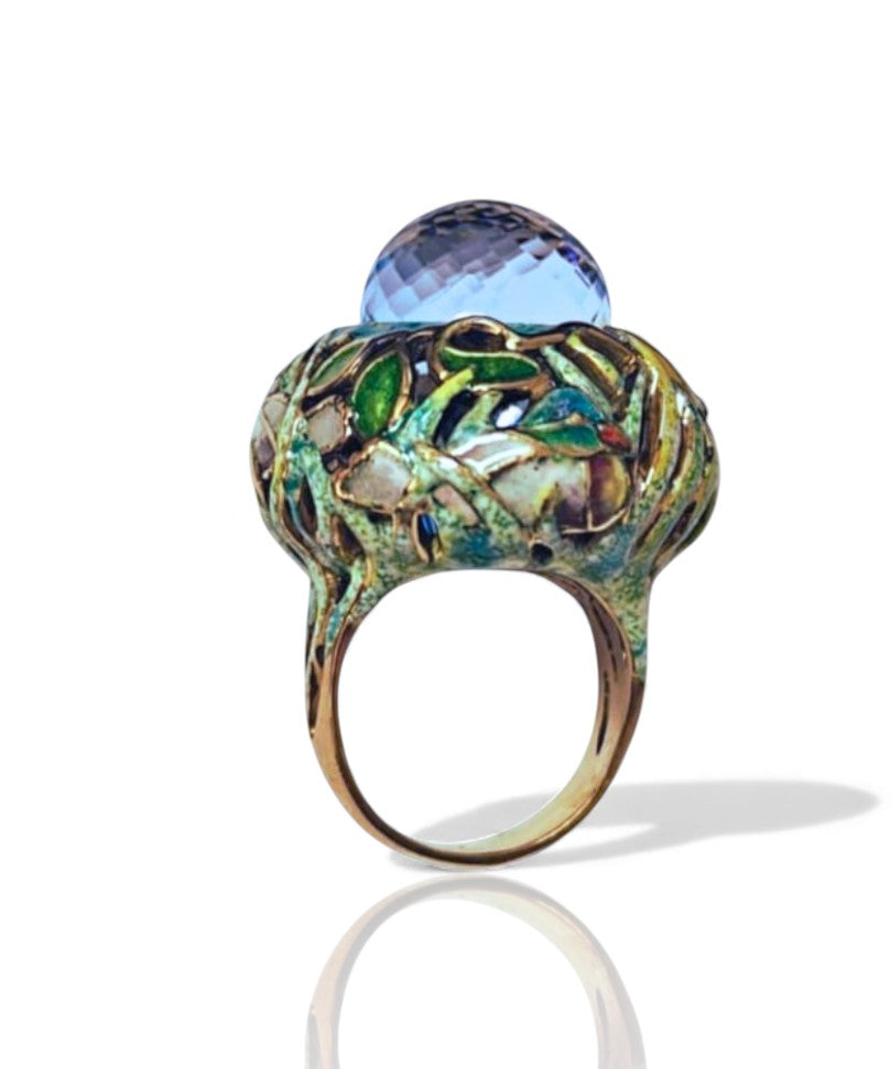 Angled image of the Shimmering Pond ring showing the depth of the Swiss topaz briolette, vivid Champlevé enamel detailing, and artisan-crafted 18K gold design.