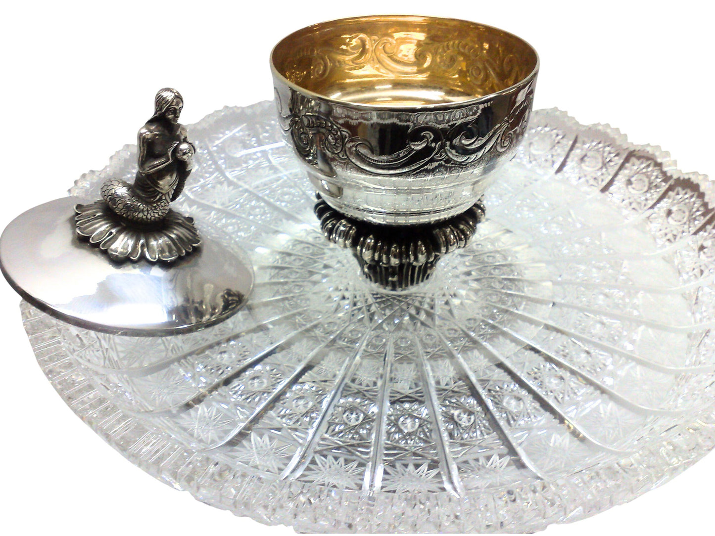Lid-off view of the “Enchantress of the Sea” sculptural silver caviar server, revealing the interior caviar bowl set above a crystal platter, with the mermaid handle and maritime sculptural details visible.
