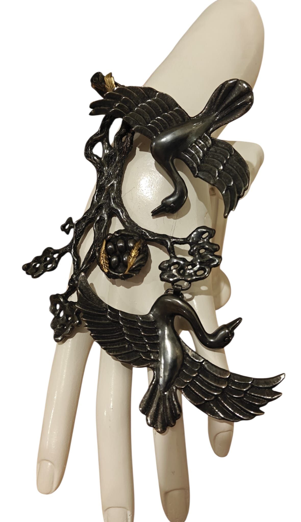 Song of the Nest ring and bracelet set by Konforti Jewelry shown on a hand, featuring handcrafted 960 silver with 24K gold plating and artistic tarnishing inspired by a protective nest design.