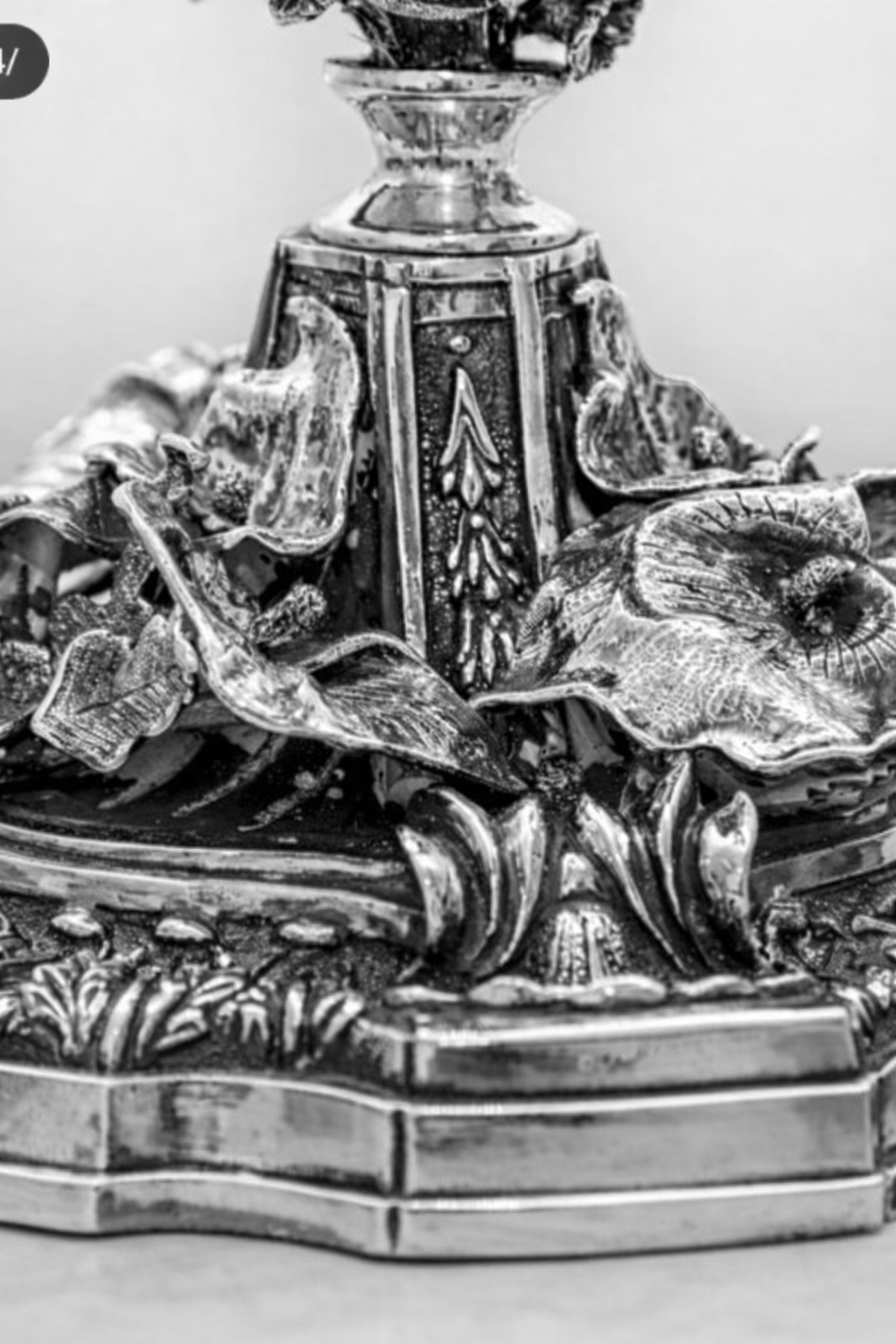 Close-up of menorah base in sterling silver with sculptural botanical design, layered ornamentation, and polished and hammered finishes